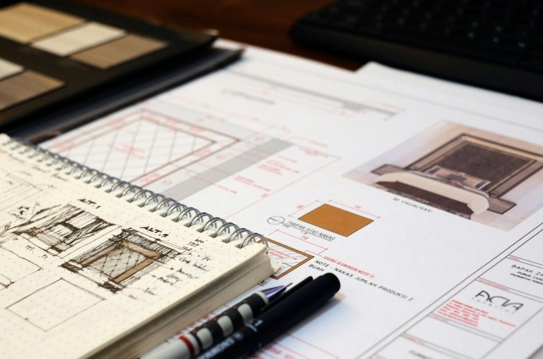 Croquis architectural, échantillons de matériaux et plans sur une table de travail.