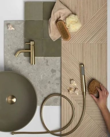 Éléments de salle de bain comprenant des carreaux, un robinet doré et des accessoires.