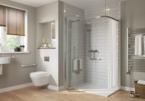 Salle de bain moderne avec douche vitrée, toilettes suspendues et carrelage blanc.