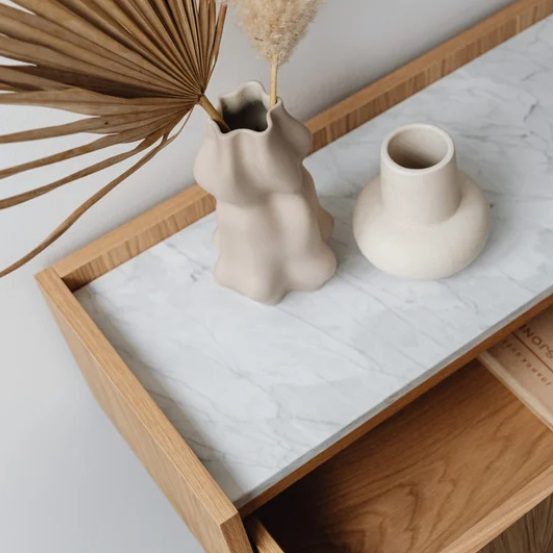Vases en céramique sur une table en bois avec décoration florale sèche.