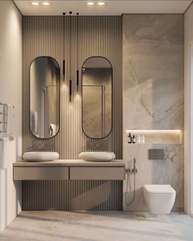 Salle de bain moderne avec des miroirs ovales, meubles minimalistes et toilettes suspendues.