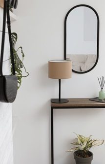 proposition d’aménagement intérieur d’une cuisine Mur sombre avec des bandes lumineuses verticales et un banc en osier. Plante en pot sur le comptoir.