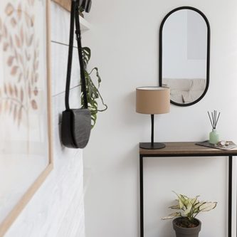 proposition d’aménagement intérieur d’une cuisine Mur sombre avec des bandes lumineuses verticales et un banc en osier. Plante en pot sur le comptoir.