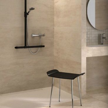 Salle de bain moderne avec douche, lavabo et banc noir.