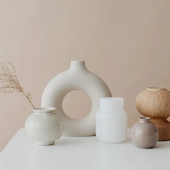 Vases en céramique de formes variées sur un fond beige.