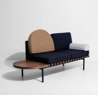 Canapé moderne avec accoudoir rond en bois et coussin bleu sur une base noire.