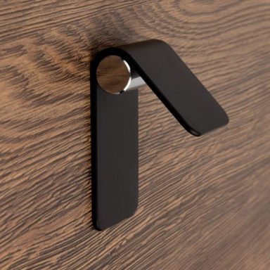 Poignée noire moderne fixée à un mur en bois.