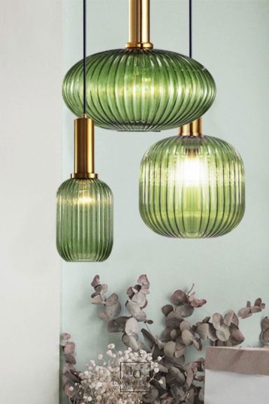 Suspensions en verre vert avec une finition striée et des détails dorés.