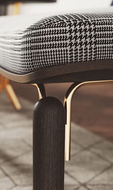 Coin d'un mobilier moderne avec un coussin à motif géométrique et fixation dorée.