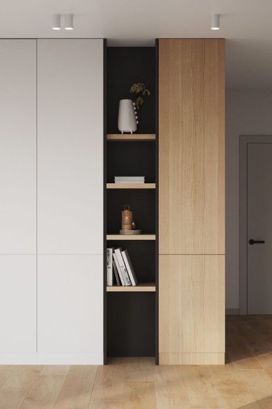 Étagère moderne en bois clair avec compartiments noirs et objets décoratifs.