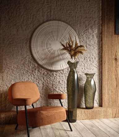 Fauteuil orange avec table d'appoint, décoré de vases en verre et d'une sculpture murale.