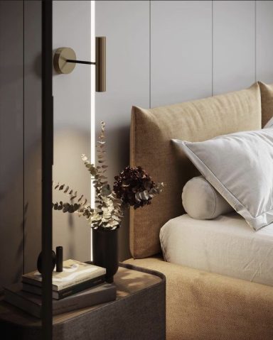 Chambre minimaliste avec lit beige, coussins et lampe design, décorée de fleurs sèches.