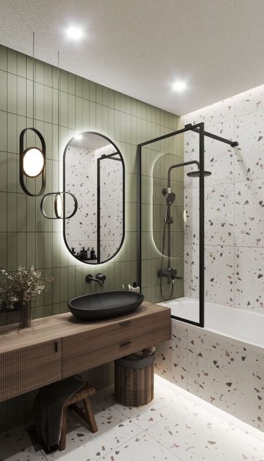 Salle de bain moderne avec carrelage vert, baignoire et meuble en bois.