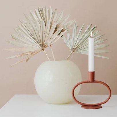 Architecte d'intérieur Coulommiers pour gestion de projet déco Vase blanc avec des feuilles sèches et un chandelier rouge.