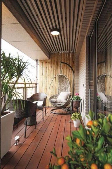 Balcon avec des chaises suspendues, des plantes et des agrumes en pot.